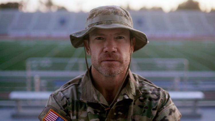 nate boyer in army uniform standing in front of empty football stadium